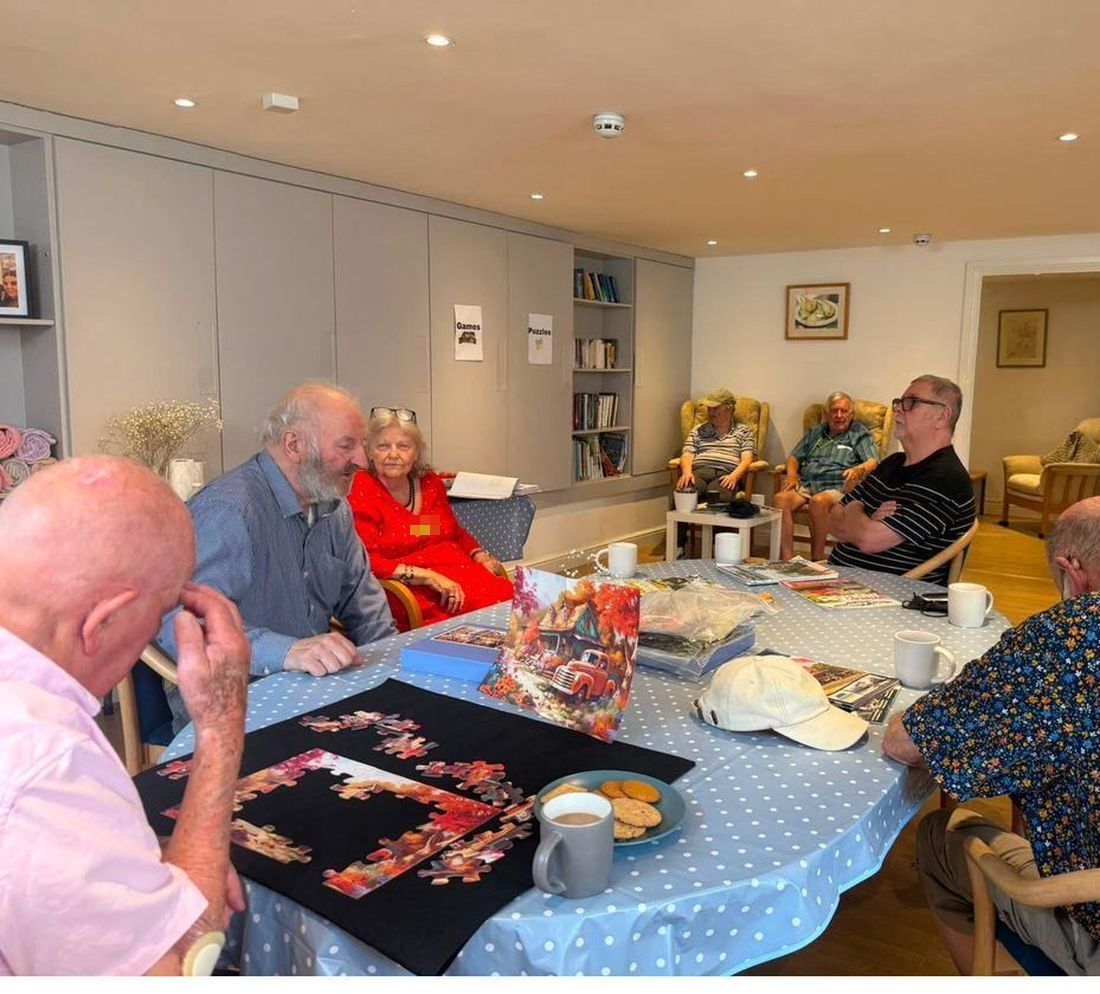 A jigsaw on the go over mugs of tea and a plate of biscuits